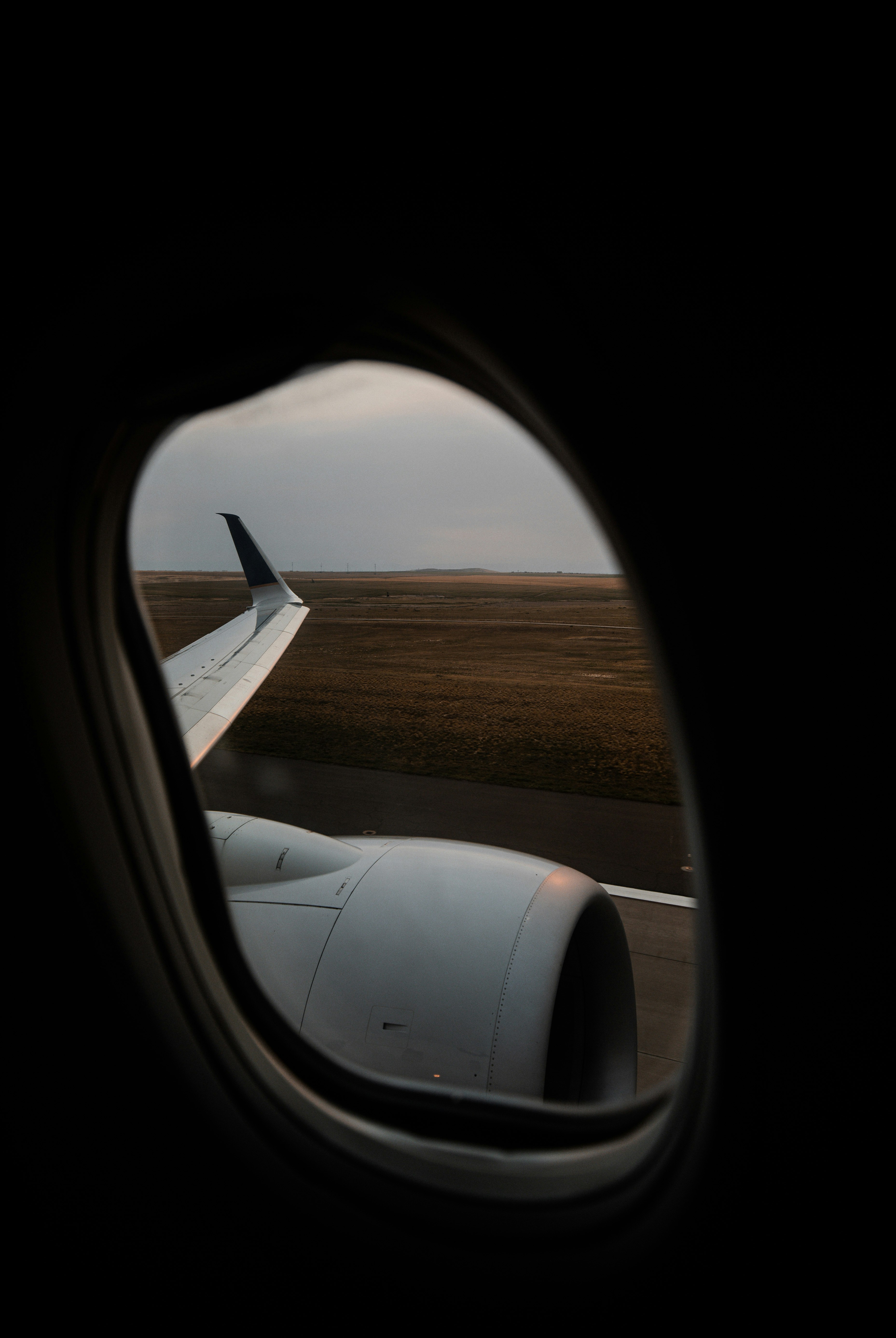 white airplane wing over brown field during daytime